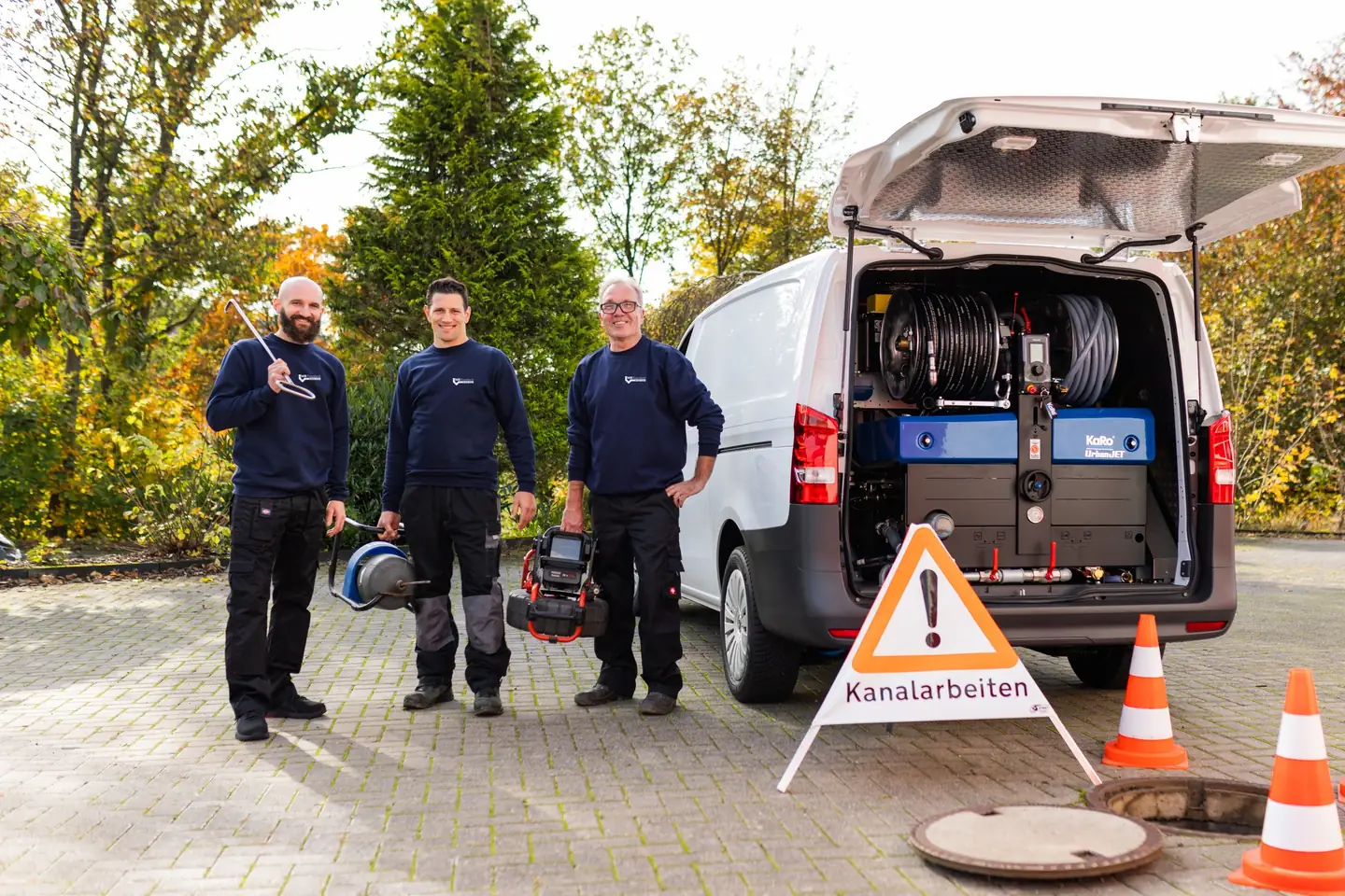Drei Techniker der MB Kanaltech München GmbH an der abgesicherten Einsatzstelle