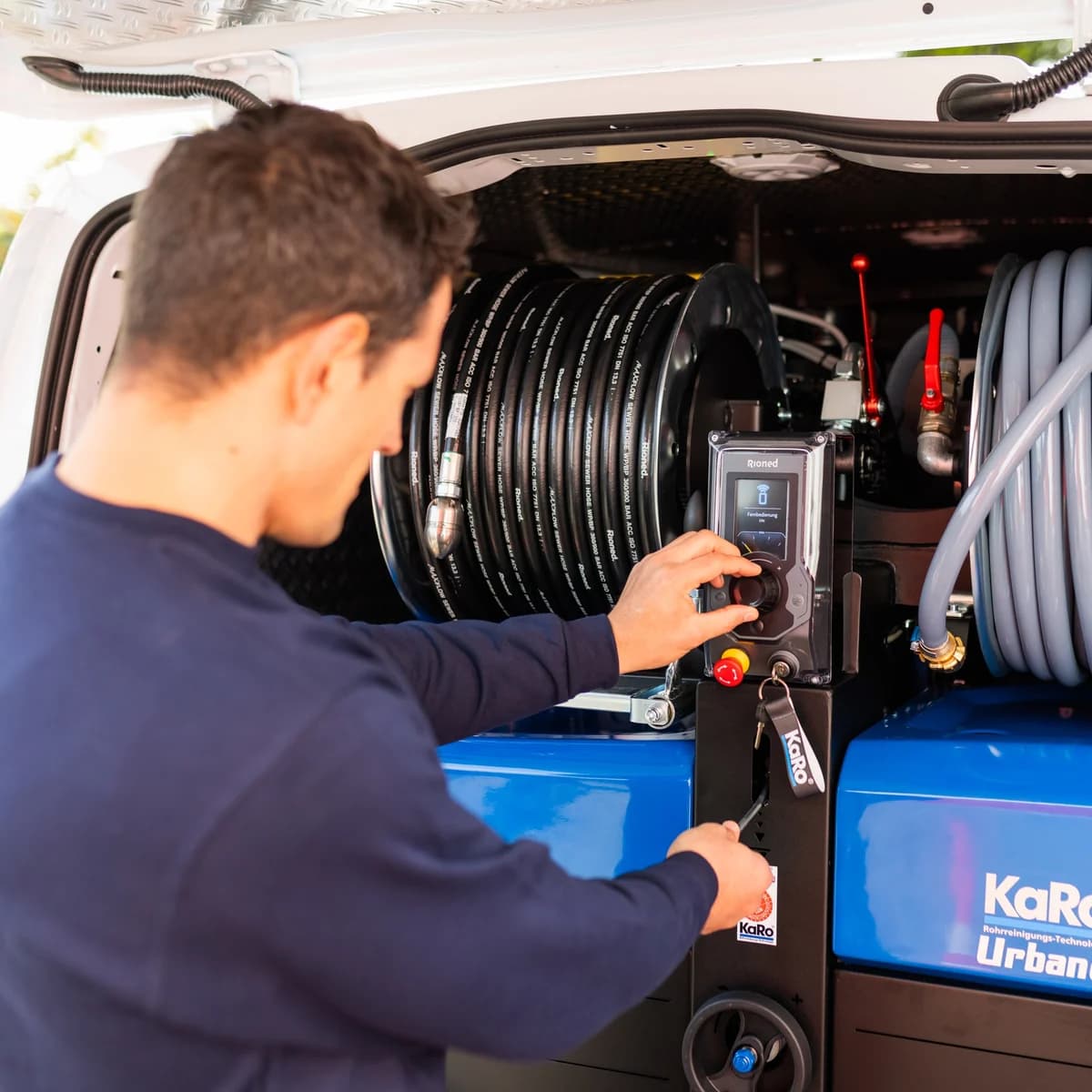 Techniker der MB Kanaltech München GmbH bedient das Hochdruck-Spülgerät im Fahrzeug